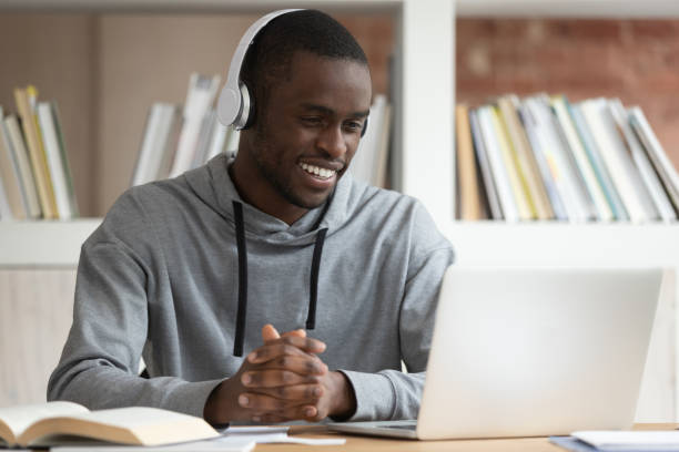 istock Smiling black male watch online training course at laptop 1163323478