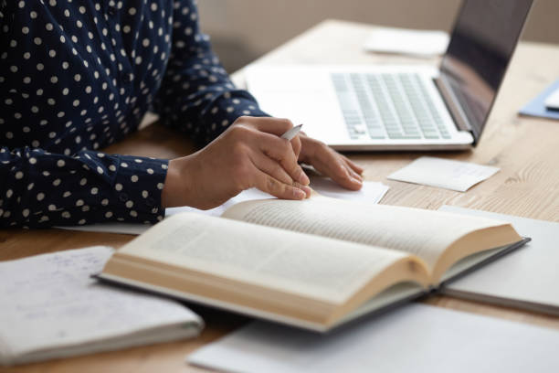 istock Close up of female student read book preparing for exam 1163323479