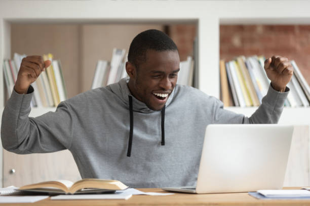 istock Happy black male student get pleasant email on laptop 1163323483
