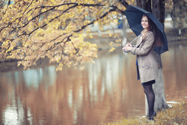 istock Young girl in a coat in autumn  park 1163329207