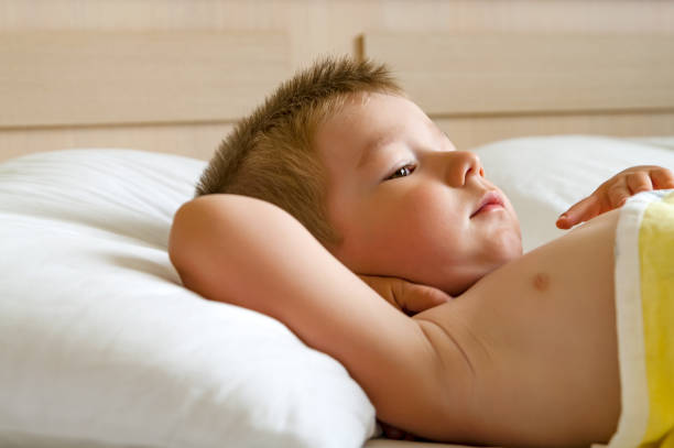 istock Cute little boy lying in bed. 1163329912