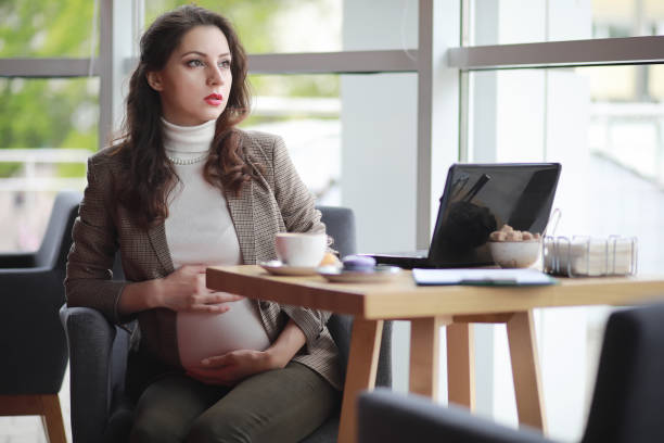 istock Pregnant woman working on computer in cafe 1163332705