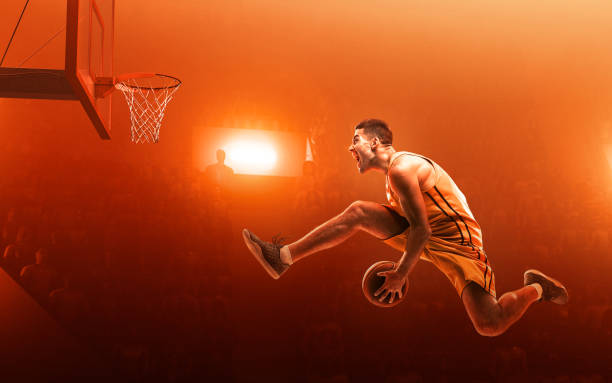 istock Basketball player in action. Slam Dunk. Red scattered light background 1163332857