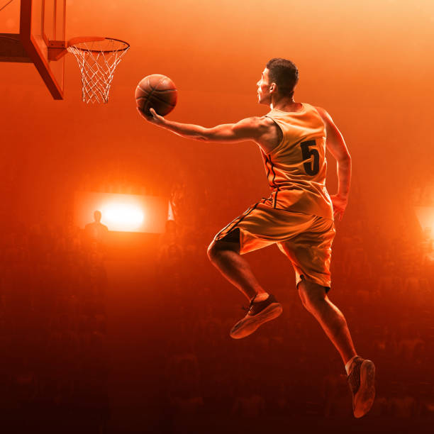 istock Basketball player in action. Slam Dunk. Red scattered light background 1163332913