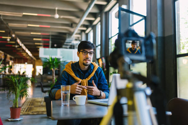 Young male vlogger making content on camera stock photo