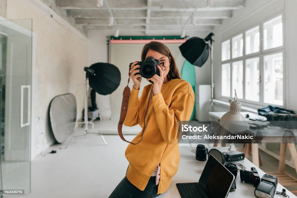 Fotógrafo trabajando en un estudio - Foto de stock de Fotógrafo libre de derechos