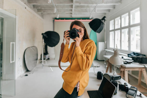 スタジオで働く写真家 - 女性一人 写真 ストックフォトと画像