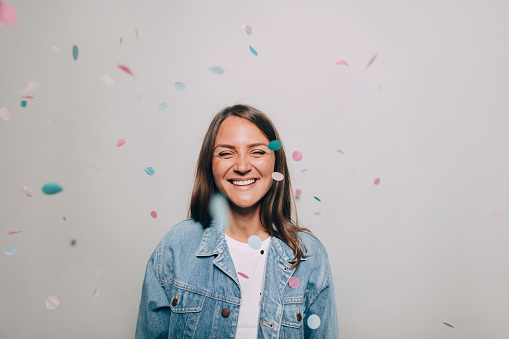 Smiling woman throwing confetti