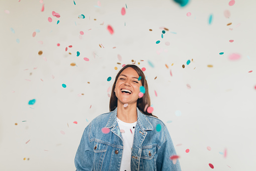 Smiling woman throwing confetti