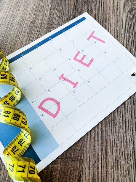istock Diet plan concept. Measuring tape and diet plan on wooden background. 1163337234
