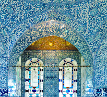Classical oriental design  on wall with tiles and arched stained glass windows  at Topkapi Palace in Istanbul, Turkey.