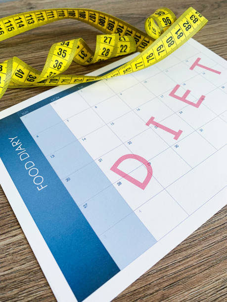 istock Diet plan concept. Measuring tape and diet plan on wooden background. 1163338192