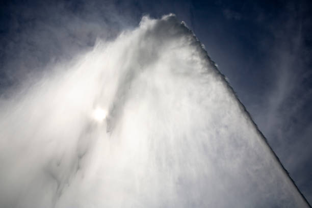 The Jet d'Eau (Water-Jet) is a large fountain in Geneva, Switzerland, and is one of the city's most famous landmarks. Silhouette against the ble sky.