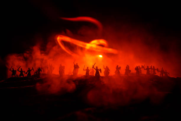 istock Medieval battle scene with cavalry and infantry. Silhouettes of figures as separate objects, fight between warriors on dark toned foggy background with medieval castle. 1163338486