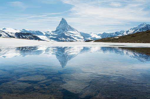 Swiss Alps, Matterhorn mountain landscape with reflection on melting frozen lake in Zermatt, Switzerland