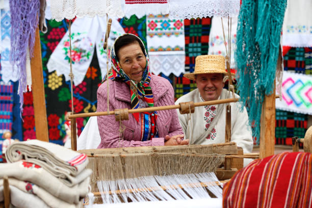 istock Grandmother works behind an old spinning machine.Spice on an old spinning wheel. Ancient fabrication. Woman weaver 1163339257