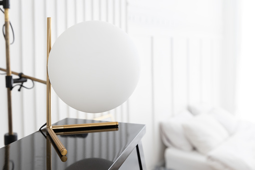 close up of interior sphere white ball lamp on piano with blurry bed room background.