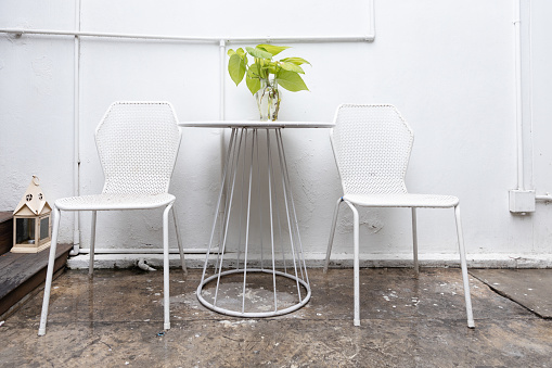 modern metal white chair and table at outdoor cafe in rainy day.