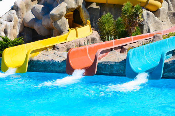 istock Multi-colored water slides with water jets in the blue pool 1163342465