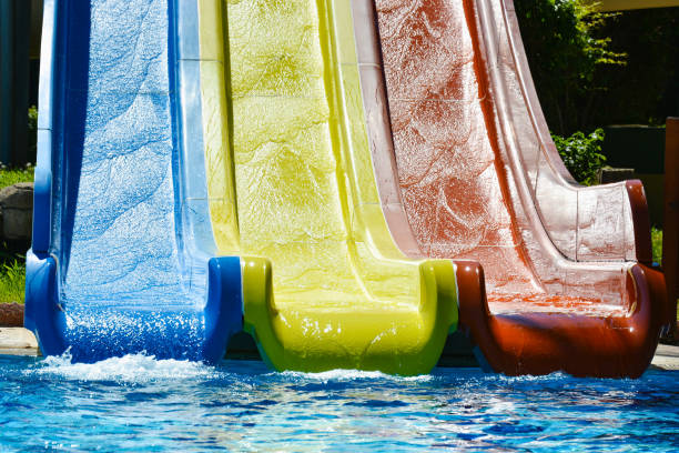 istock Multi-colored water slides with water jets in the blue pool 1163342508