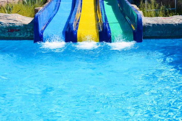 istock Multi-colored water slides with water jets in the blue pool 1163342547