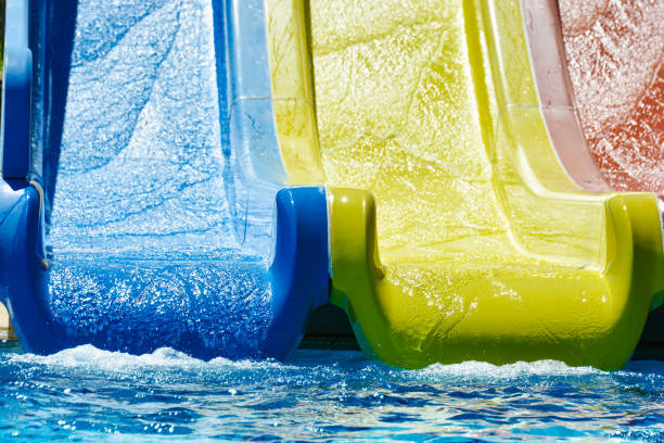 istock Multi-colored water slides with water jets in the blue pool 1163342563