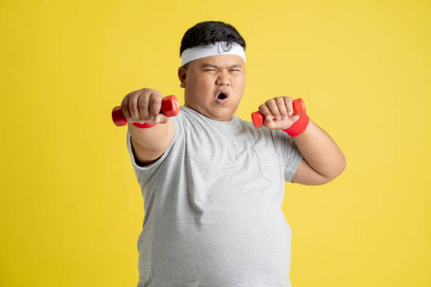 Fat men are exercising by lifting weights. Fat men are exercising by lifting weights. overweight boy stock pictures, royalty-free photos & images