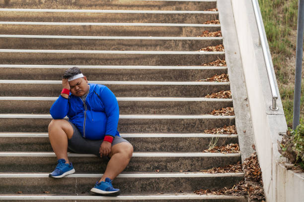 Fat man, he is tired and discouraged From exercise Fat man, he is tired and discouraged From exercise overweight boy stock pictures, royalty-free photos & images