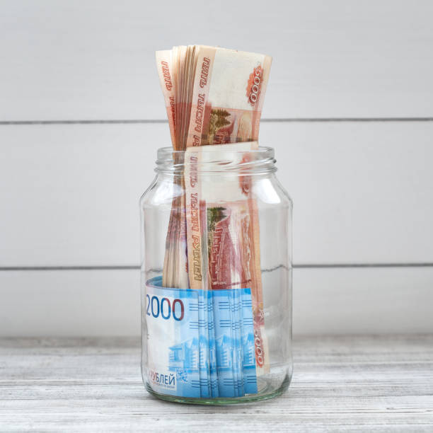 istock Glass jar filled with money on a light background. Russian banknotes 1163351594