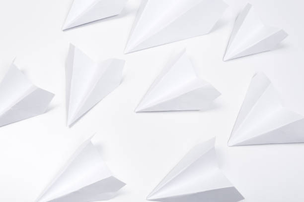 istock white paper airplane on a white paper background 1163356748