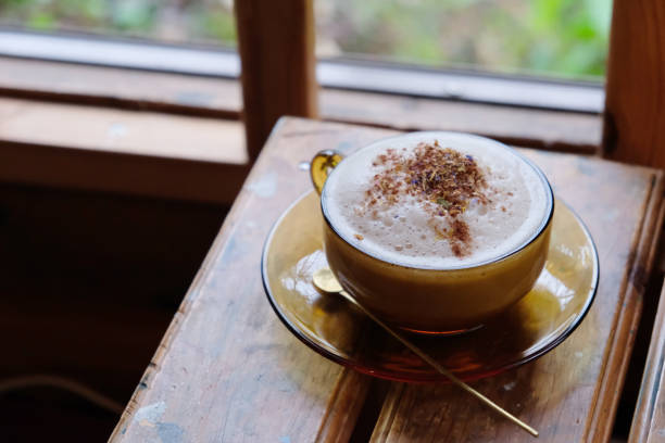 A foamy chai latte at cafe in Japan. Masala chai is a flavoured tea beverage made by brewing black tea with a mixture of aromatic spices and herbs. Japanese style of chai latte. chai stock pictures, royalty-free photos & images
