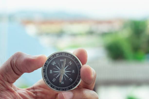 istock man holding compass on blurred background. for activity lifestyle outdoors freedom or travel tourism and inspiration backpacker alone tourist travel or navigator image. 1163357783