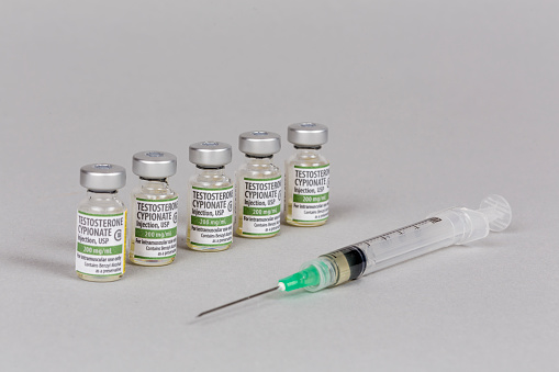 Five vials and a syringe containing Testosterone Cypionate for injection. Label is designed and printed by the photographer.