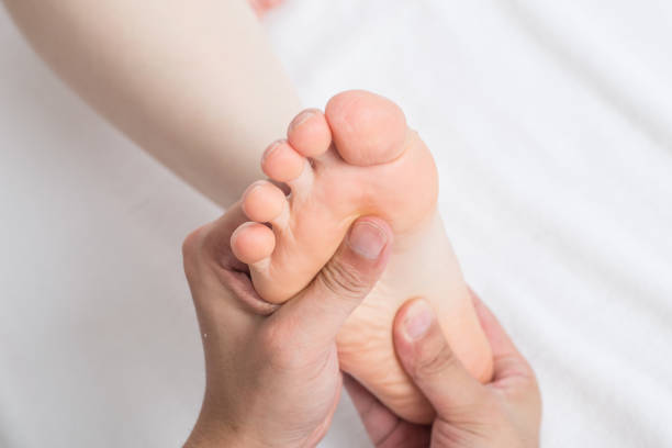 istock Close-up of female hands doing foot massage 1163358236