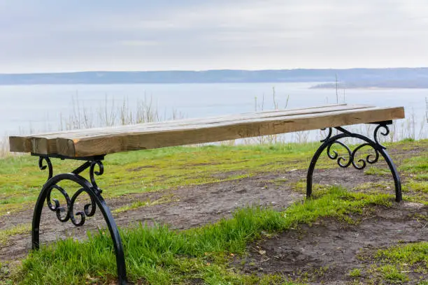 Photo of Lonely bench installed on the high mountain of the city Tetyushi. Observation deck with a magnificent view of the Volga. Beautiful landscape.