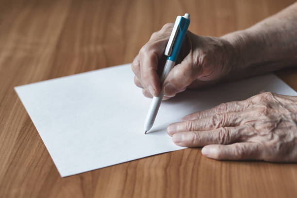istock Pensioner writes in pen on paper. 1163358498