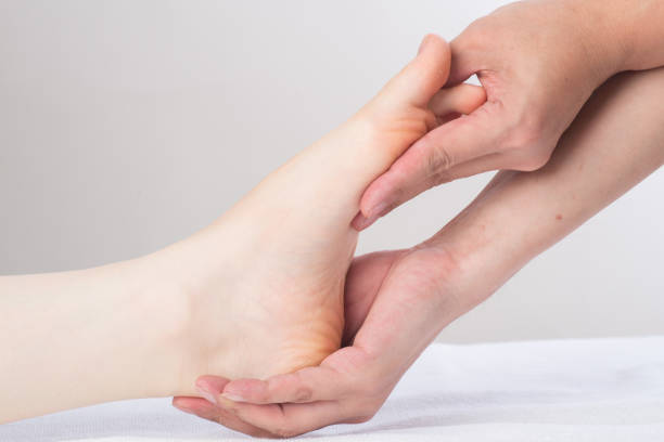 istock Close-up of female hands doing foot massage 1163359334