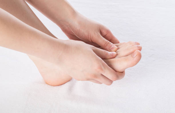 istock Close-up of female hands doing foot massage 1163359339