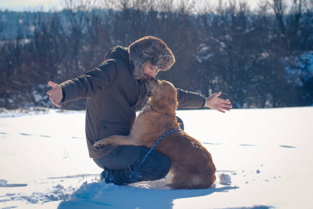 istock Man enjoying with golden retriever at winter 1163359475
