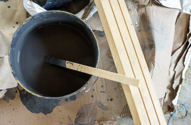 Mixing paint in a bucket with a wooden stick stock photo