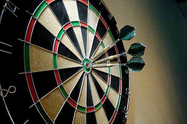 tres de dardos en bullseye - dartboard fotografías e imágenes de stock