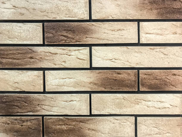 istock Decorative panel in the form of a beige and brown old brick. 1163360389
