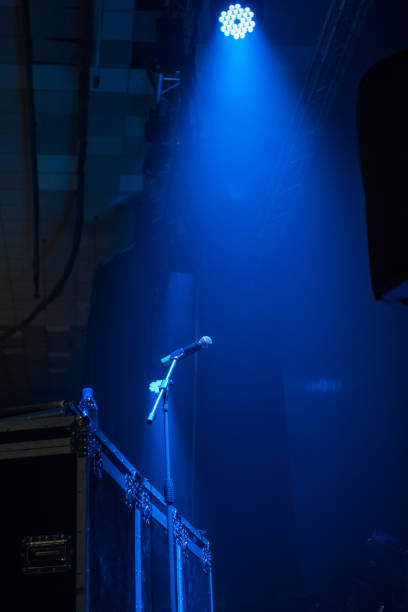 istock microphone in concert hall with blue lights 1163361134