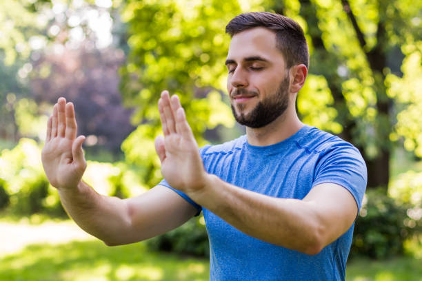 homme bel exerçant tai chi - tai chi photos et images de collection