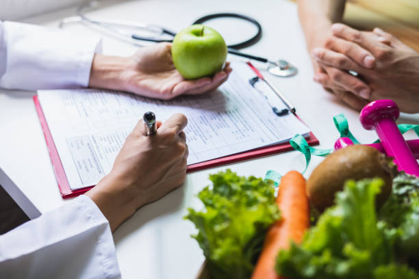 Nutritionist giving consultation to patient with healthy fruit and vegetable, Right nutrition and diet concept stock photo