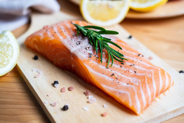 istock Fresh salmon steak with herbs, lemon and ingredients for cooking in kitchen 1163365096