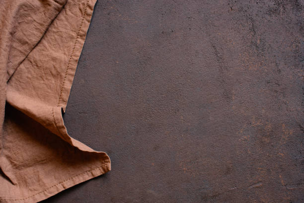 Brown textured kitchen background with linen napkin Brown textured kitchen background with linen napkin, copy space restaurant table layout stock pictures, royalty-free photos & images