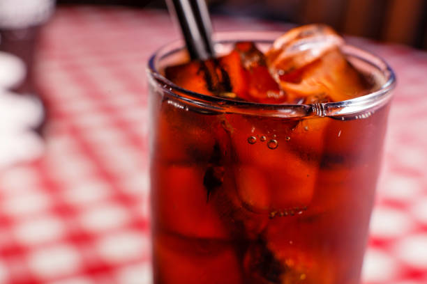 istock Cold drink beverage. Cola soda with ice and bubble on front view red and white background. 1163365888