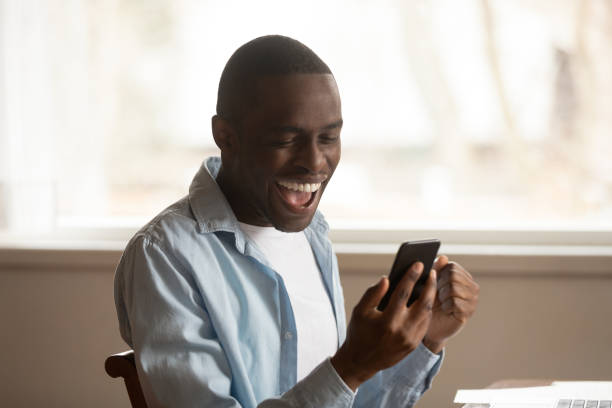 istock African guy look at cellphone read great news feels happy 1163367343