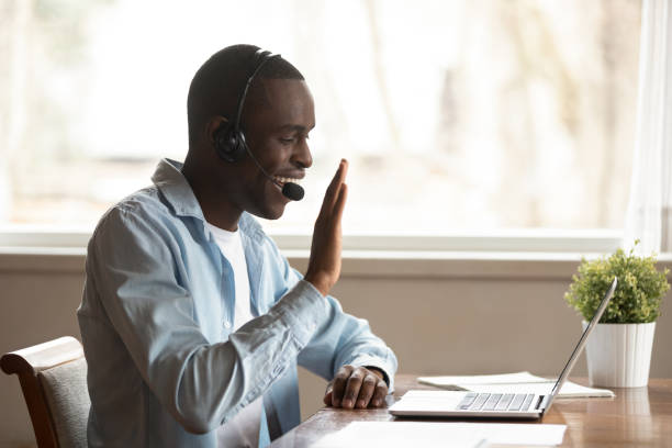 istock African guy wearing headset starting lesson online greeting tutor 1163367351